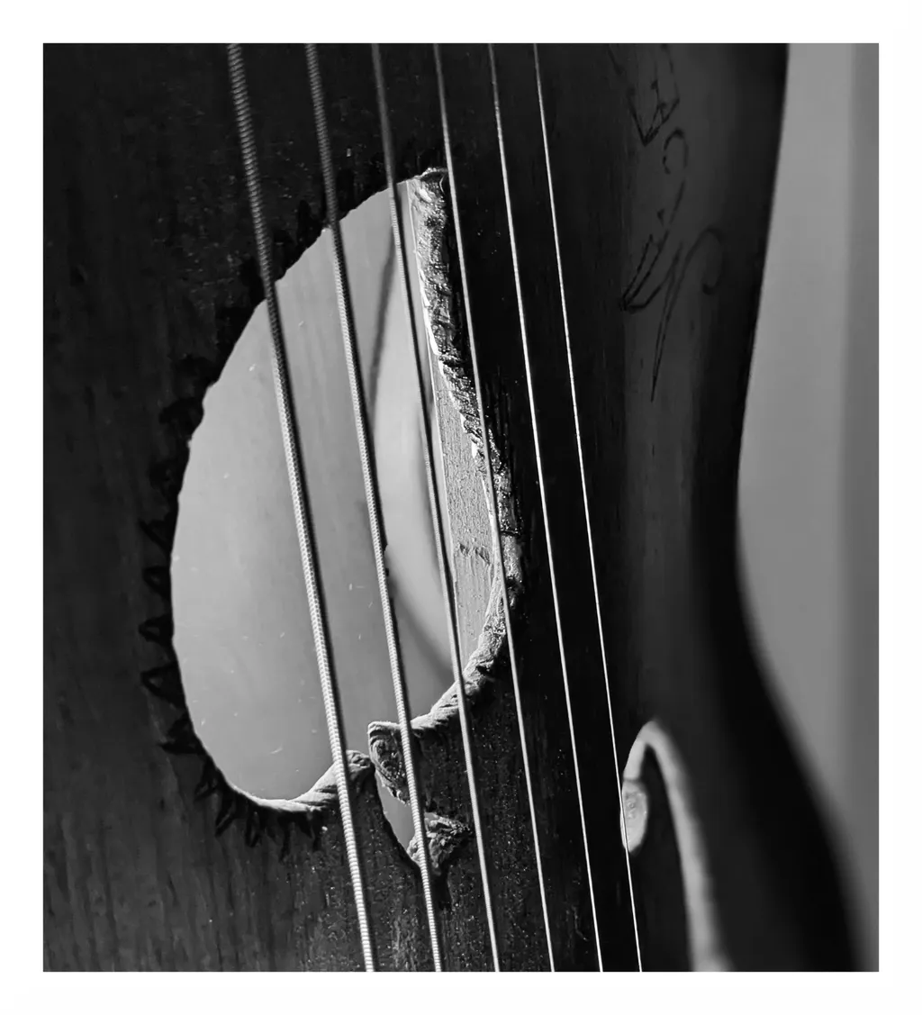 Fire de praf și lumină, ieșind din cutia unei chitare